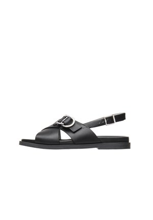 Sorte lædersandaler med flad sål, åbent tådesign, krydsede stropper og en metallisk spændeudsmykning på den forreste rem.