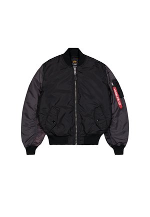 Chaqueta bomber negra con cremallera frontal, puños acanalados, dos bolsillos con solapa y un bolsillo en la manga con cremallera que presenta una etiqueta roja "Retirar antes de volar".