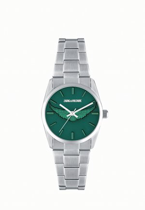 Reloj de pulsera de metal plateado con esfera verde, diseño de alas en el centro, marcadores de hora plateados y logo de Zadig & Voltaire en la parte superior.