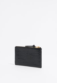Billetera negra con relieve de cocodrilo y textura suave, que cuenta con un cierre dorado y una forma rectangular delgada.