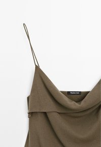 Olijfgroene mouwloze jurk met dunne spaghetti bandjes en een gedrapeerde kraaglijn, met zichtbaar label van Massimo Dutti.