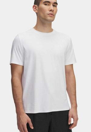 Witte sportieve t-shirt met korte mouwen, voorzien van perforaties op de schouders en een ronde halslijn. Gecombineerd met geruite shorts.