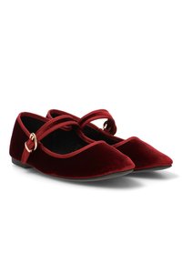 Bailarinas de terciopelo rojo con punta afilada, que cuentan con una tira cruzada y un pequeño detalle de hebilla dorada en el costado. Suela plana.