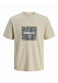 Beżowa koszulka z bawełny, z kwadratowym szarym nadrukiem graficznym w czarny wzór kamuflażu oraz białym napisem "jack&jones CORE NINE ZERO."
