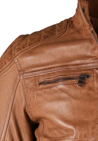 Braune Lederjacke mit strukturierter Oberfläche, ausgestattet mit einer Reißverschlusstasche auf der Brust und gesteppter Schulterverzierung.