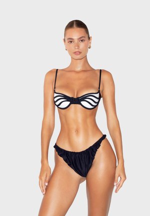 Bikini bianco e nero con top strutturato a scallop e spalline sottili, abbinato a slip a vita alta arricciati, realizzati in tessuto morbido.