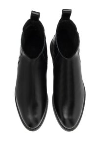 Melna ādas potītes zābaku pāris ar vilkšanas cilpām, skatīti no augšas uz baltā fona.