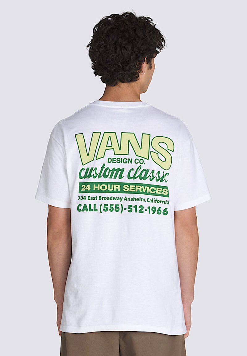 Camiseta blanca de algodón con texto gráfico verde en la parte posterior. El texto incluye "VANS DESIGN CO." y detalles del servicio en varias tamaños de fuente.