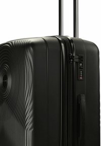 Schwarzer Hartschalenkoffer mit konzentrischen Kreismustern, ausziehbarem Griff, Seitengriff, Reißverschluss und integriertem TSA-Kombinationsschloss.