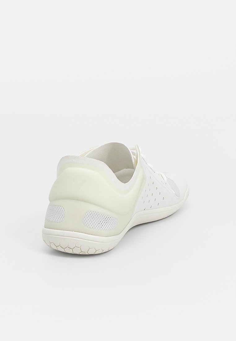 Zapatilla deportiva blanca con parte superior de malla transpirable, suela de goma texturizada y acentos en colores claros, diseñada para comodidad y soporte.