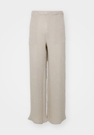 Béžové nohavice s širokými nohavicami vyrobené z textúrovanej látky, s vysokým pásom a jednoduchým, čistým dizajnom bez viditeľných zapínaní alebo ozdôb.