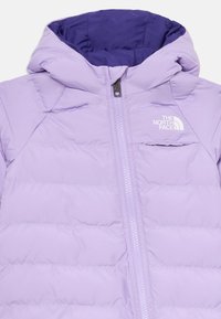 Šviesiai violetinė pūkinė striukė su gobtuvu, su priekiniu užtrauktuku ir krūtinės kišene. Lygus paviršius ir siuvinėtas dizainas su logotipu krūtinėje.