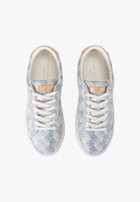 Sneakers bianchi con un motivo a pois blu, dotati di una superficie testurizzata, dettagli rosa chiaro sul tallone e lacci bianchi.