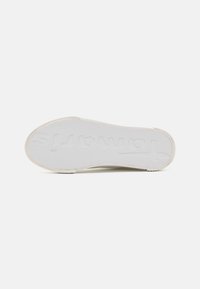 Biała gumowa podeszwa buta z teksturowanym wzorem, z wytłoczonym logo marki "Toms" i minimalistycznym wzorem bieżnika.