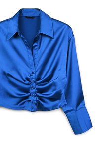 Blusa blu in satin a maniche lunghe con colletto a punta, bottoni arricciati frontali e maniche con polsini, stesa su uno sfondo bianco.
