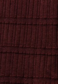 Gros plan sur un tissu tricoté bordeaux foncé avec une texture côtelée et des détails de bandes horizontales.