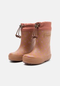 Botas de lluvia de goma con patrón de corazones rosas, suela marrón texturada y puño de tela rosa, que cuentan con un cierre de cordón en la parte superior.