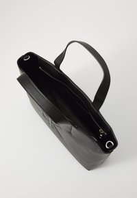 Borsa tote in pelle nera con superficie testurizzata, un manico superiore singolo e una tasca interna con zip. Presenta un design minimalista e un logo embossato.
