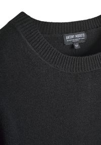 Zwarte gebreide sweater met een geribde ronde hals. Gemaakt van een viscose-mix, met een zachte textuur en een label met details over maat en merk.