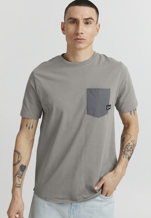 Gray short-sleeve t-shirt in soft cotton with a contrasting dark gray chest pocket and a logo tag on the pocket. Smooth texture, relaxed fit.