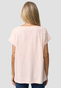 Lyserød kortærmet T-shirt med rund hals, afslappet pasform og opsmøgede ærmer, lavet af blødt, let bomuldsblandingsmateriale.