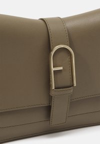 Pochette en cuir taupe avec une sangle dotée d'une boucle en métal doré en forme de "F" inversé.