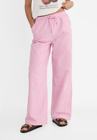 Pantalons larges rayés roses avec une taille à cordon, en tissu léger, dotés de deux poches latérales et d'une coupe décontractée.
