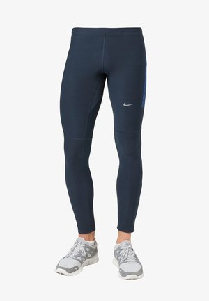 Granatowe legginsy sportowe wykonane z elastycznej tkaniny, z geometrycznym panelem z siateczki po prawej stronie oraz srebrnym logo z przodu.