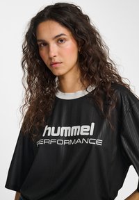 Black short-sleeve t-shirt with a striped texture and white collar, featuring a large white "hummel PERFORMANCE" logo on the front.