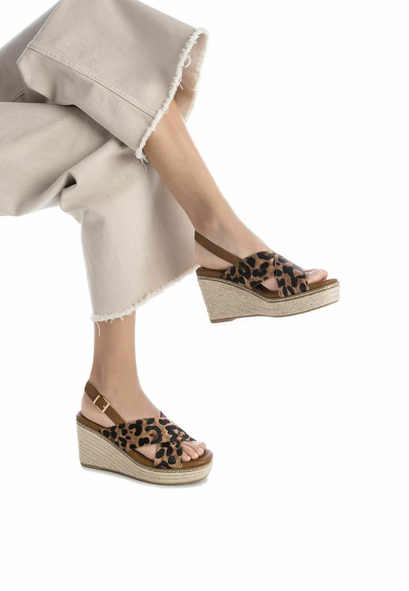 Sandalias de cuña con estampado de leopardo, base de yute trenzado y tiras marrones que presentan un diseño entrelazado, punta abierta y plantilla acolchada.
