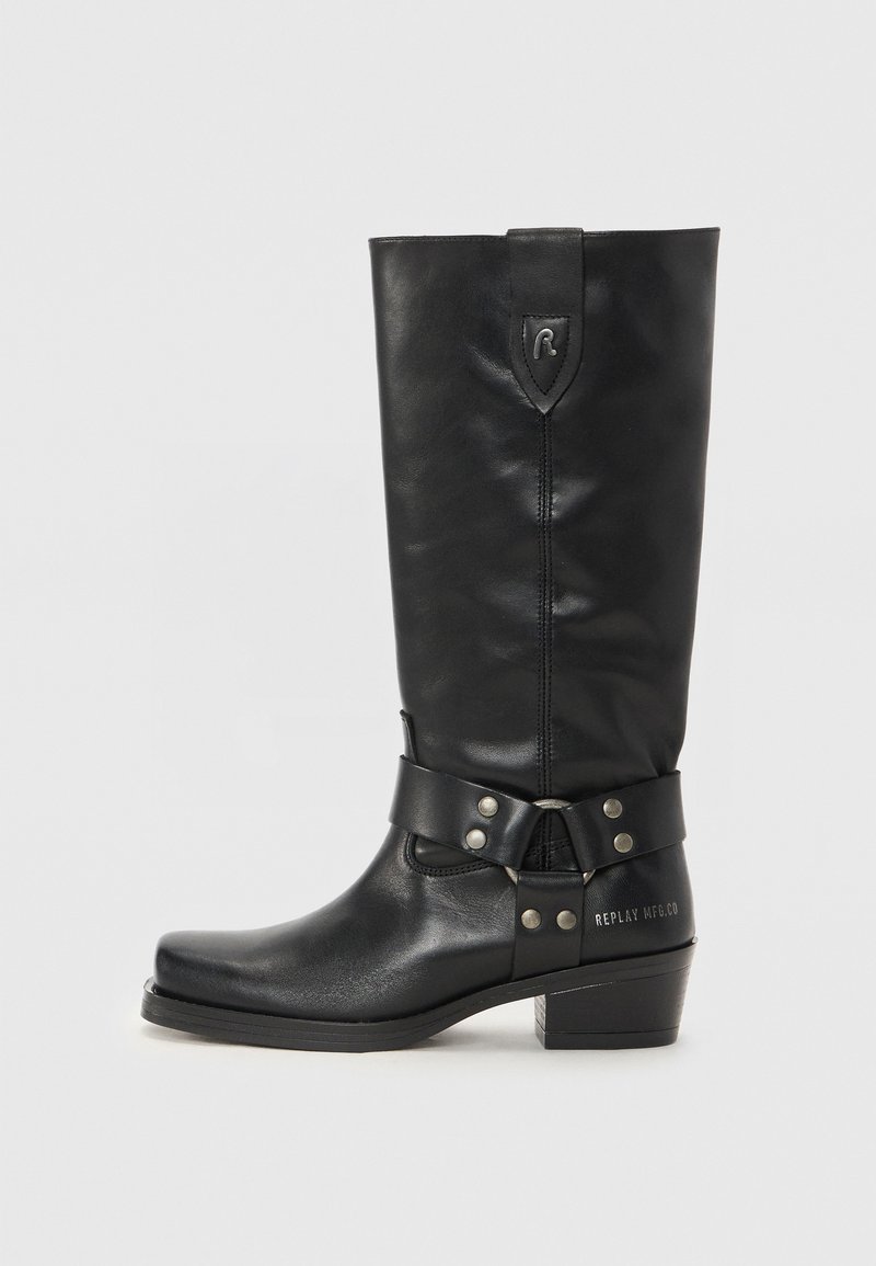 Botas altas de cuero negro hasta la rodilla con punta redonda, una correa con herrajes plateados y un tacón bajo apilado. "REPLAY MFG. CO" grabado en el lateral.