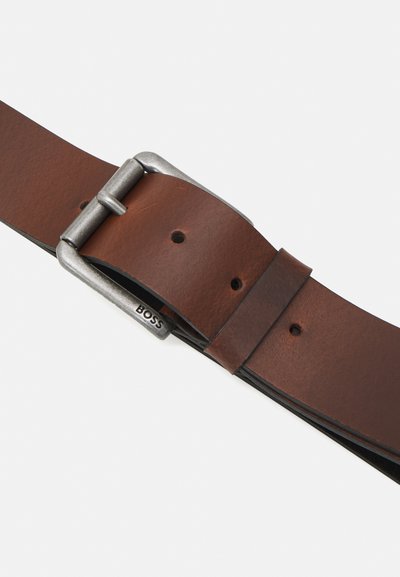 Ceinture en cuir marron avec une boucle en métal argenté comportant un détail de marquage. La ceinture dispose de plusieurs trous pour un ajustement.
