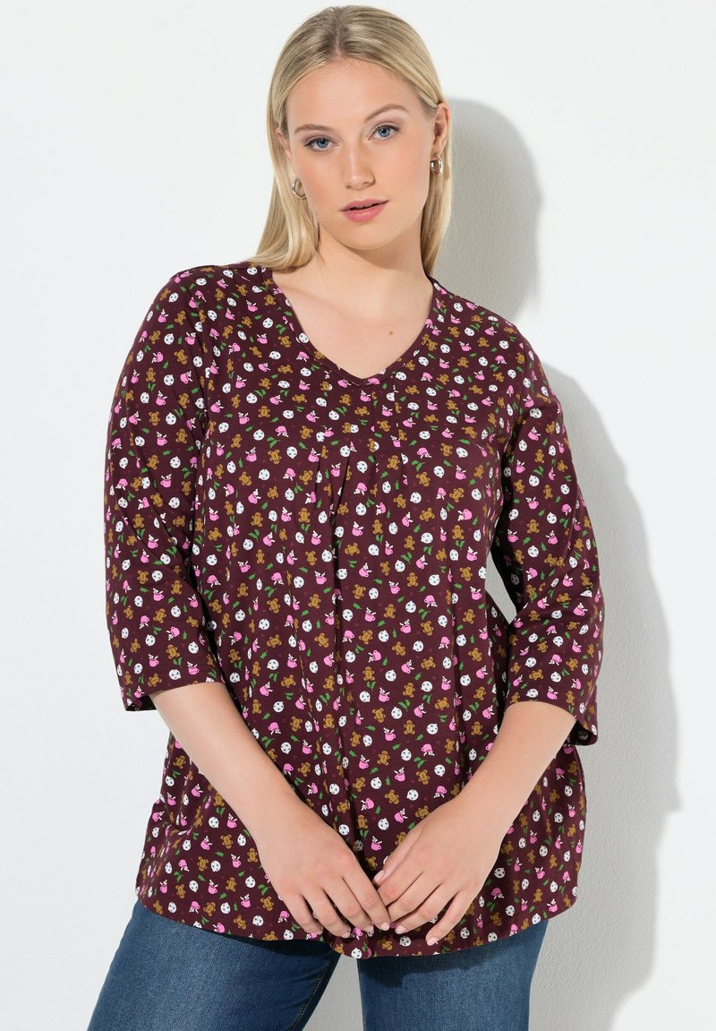 Blusa burdeos con escote en V, mangas 3/4 y un patrón divertido de pequeñas ilustraciones multicolores. Corte holgado y fabricada con tela suave.