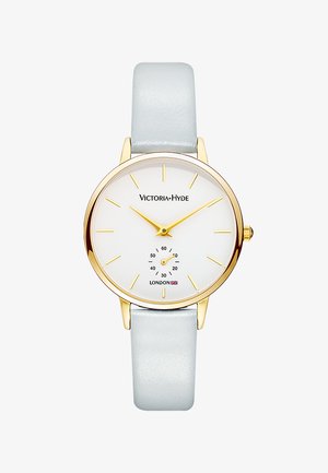 Montre ronde avec un cadran blanc, des marqueurs et aiguilles dorés, un sous-cadran argenté, un boîtier doré et un bracelet en cuir bleu clair. Nom de la marque : Victoria-Hyde.