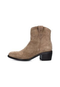 Bottine en suédine beige avec un bout pointu et un petit talon noir. Présente des détails de couture et une languette en haut.