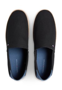 Μαύρα παπούτσια χωρίς κορδόνια με υφασμάτινο επάνω μέρος με υφή, εσωτερική επένδυση σε μπλε χρώμα και ελαφρώς καφέ σόλα με ραφές.