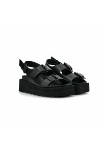 Sandalias de plataforma negras con correas anchas, hebillas ajustables y suela estriada para mayor agarre. Hechas de un material sintético suave.