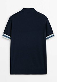 Polo shirt bleu marine à manches courtes avec un col et des rayures blanches, bleu clair et bleu marine sur les poignets, vu de dos.