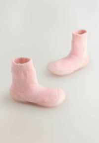 Różowe dzianinowe skarpetki o miękkiej fakturze i przezroczystej gumowej podeszwie, sięgające tuż powyżej kostki, o bezszwowym wzornictwie.