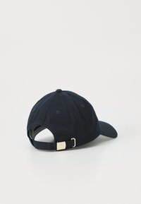 Casquette de baseball bleu marine en coton, avec une visière incurvée, un design à six panneaux et une boucle en métal doré sur la sangle réglable.