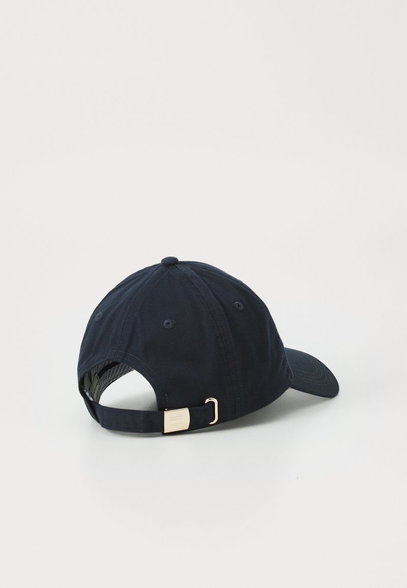 Casquette de baseball bleu marine en coton, avec une visière incurvée, un design à six panneaux et une boucle en métal doré sur la sangle réglable.