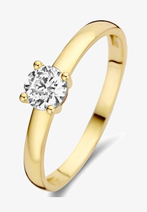Bague en or avec un diamant rond taillé en brillant maintenu par quatre griffes. Anneau lisse et poli avec un profil arrondi. Design simple et élégant.