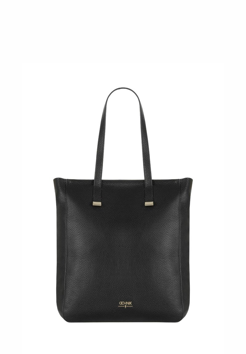 Czarna skórzana torba typu tote ma fakturowaną powierzchnię, podwójne górne uchwyty oraz akcenty w kolorze złotym. Prosta kwadratowa forma bez widocznych zapięć.