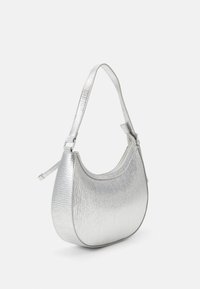 Srebrna torebka na ramię o teksturowanym wykończeniu, zaokrąglonym kształcie i regulowanym pasku. Posiada zamknięcie na zamek oraz gładką podszewkę wewnętrzną.