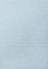 Tela de algodón azul claro con una textura suave, que presenta una costura horizontal cosida en la parte inferior. Sin patrones ni detalles adicionales.