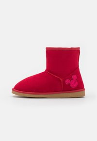 Bottes de cheville rouges en tissu doux, avec un bout rond et un logo Mickey Mouse sur le côté en matériau rose brillant. Semelle extérieure en caoutchouc marron.