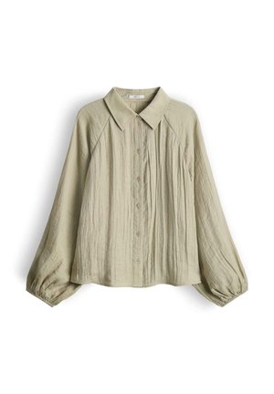 Camicia beige a maniche lunghe con bottoni, collo appuntito e polsini arricciati, realizzata in tessuto testurizzato e stropicciato.