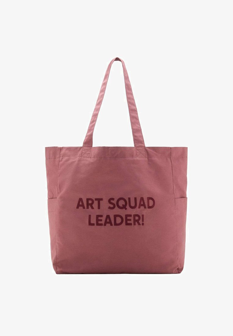 Sac fourre-tout en tissu rose avec deux anses. Présente le texte "ART SQUAD LEADER !" en marron foncé. Léger avec un design simple.