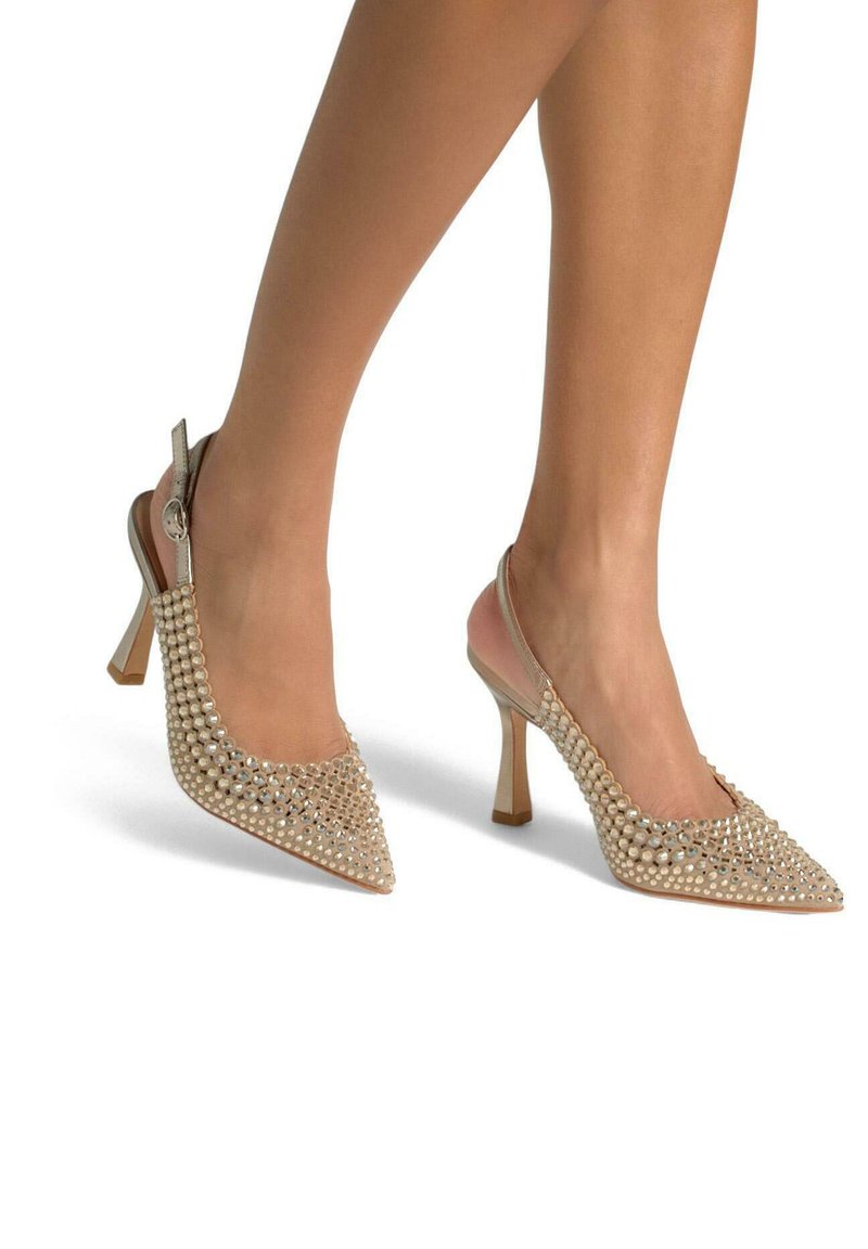 Scarpe con tacco a scomparsa beige con punta affusolata, decorate con dettagli simili a perle e una finitura lucida; presentano un tacco moderato e a blocco.