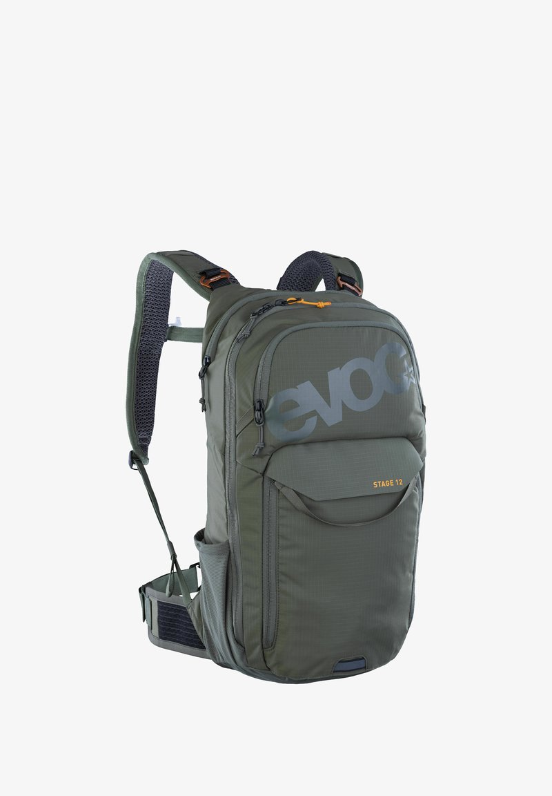 Zaino in tessuto verde con spallacci imbottiti, tasca frontale con zip, schienale in rete, grande logo e zip arancione come dettaglio.